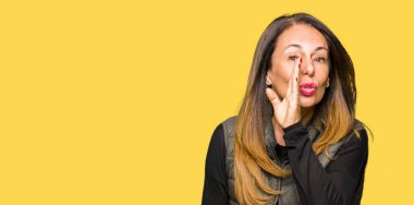 Güzel orta yaş kadın giyiyor kış yelek el gizli söylenti, kötü niyetli konuşma konuşma fısıldayarak söylemek dudaklarından