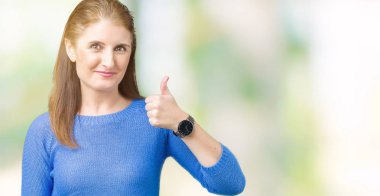 Güzel orta yaş Olgun kadın hareketi el ile mutlu yaşasın yapıyor izole arka plan üzerinde kış kazak giyiyor. Başarı gösteren kameraya bakarak ifade onaylama.