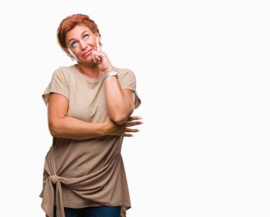 Çene düşünme hakkında soru, dalgın ifade üzerine el ile izole arka plan Atrractive üst düzey beyaz Kızıl saçlı kadın. Düşünceli yüzüyle gülümsüyor. Şüphe kavramı.