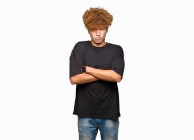 Yakışıklı genç afro saçlı siyah t-shirt şüpheci ve sinir, onaylamayan ifade yüz çapraz kollu giyiyor. Negatif kişi.