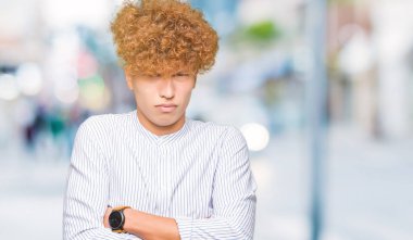 Yüz çapraz kollu şık gömlek şüpheci ve sinir, onaylamayan ifade giyen afro saçlı Genç yakışıklı iş adamı. Negatif kişi.