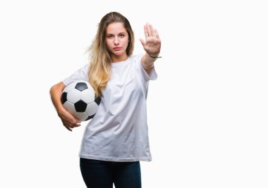 Açık eliyle dur işareti ile ciddi ve kendine güvenen ifade, savunma jest yapıyor izole arka plan üzerinde futbol topu tutan genç güzel sarışın kadın