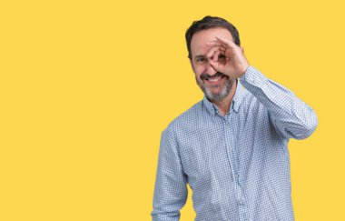 Yakışıklı orta yaş zarif komuta sizde gülümseyen, parmakları ile mutlu yüz üzerinden seyir göz el ile ok jest yapıyor izole arka plan üzerinde.