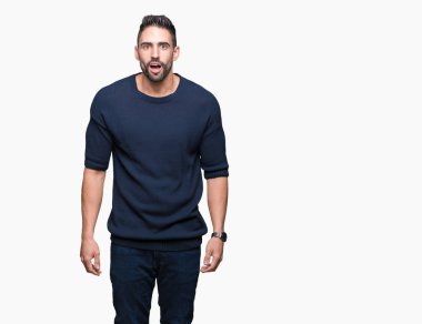 İzole arka plan korkuyor ve şok sürpriz ifade, korku ve heyecan yüz üzerinden kazak giyen genç yakışıklı adam.