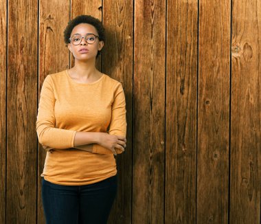 Genç güzel Afrikalı-Amerikalı kadın üzerinde gözlük takan arka plan gevşek yüzünde ciddi bir ifade ile izole. Basit ve doğal kameraya bakıyor.