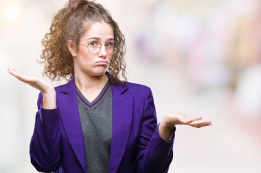 Okul üniforması ve gözlük üzerinde giyen genç esmer öğrenci kız arka plan clueless ve şaşkın bir ifadeyle kollar ve eller kaldırdı izole. Şüphe kavramı.