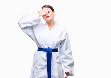 Üzerinde karate kimono üniforma giyen genç güzel kadın gülümsüyor ve gözleri için sürpriz kapsayan yüz el ile gülüyor arka plan izole. Kör kavramı.