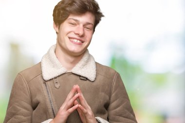 Arka plan eller üzerinde kış ceket giyen genç yakışıklı adam birlikte izole ve rahat ve neşeli gülümseyen parmak çarpı işareti. Başarı ve iyimser