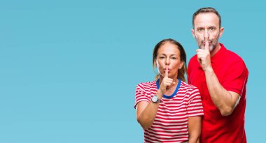 Orta yaş İspanyol çift aşk dudaklarında parmak ile sessiz olmanı izole arka plan üzerinde. Sessizlik ve gizli kavramı.