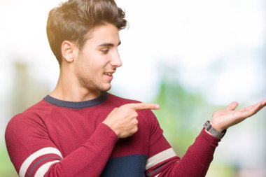 Yakışıklı delikanlı üzerinden hayran ve el ile sunulması ve parmak ile işaret ederken kameraya gülümseyen izole arka plan.