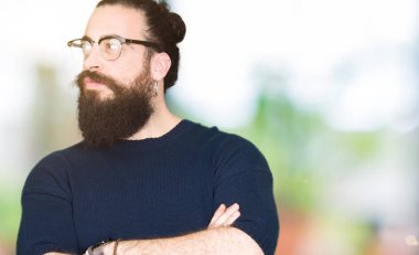 Uzun saç ve sakal gözlük gülümseyen geçti silah ile ikna yan seyir ve kendine güvenen genç hipster adamla