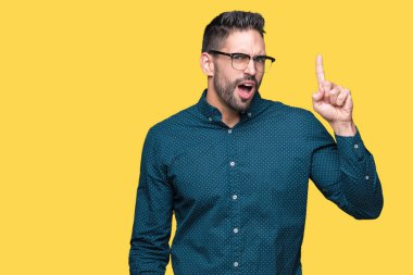 Başarılı fikirle izole arka plan işaret parmağı üzerinde gözlük takan genç yakışıklı iş adamı. Çıktıktan ve mutlu. Bir numara.