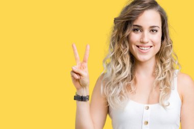 Genç güzel sarışın kadın gösterilen ve parmakları ile işaret izole arka plan yüzünden kendinden emin ve mutlu gülümseyerek ise ikinci.