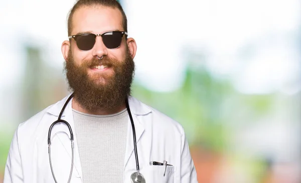 年轻的金发医生男子留着胡子戴着太阳镜 脸上带着快乐和冷静的微笑 幸运的人 — 图库照片