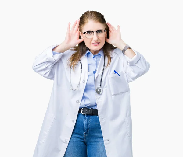 両方を聞くしようとすると 分離の背景に医療のコートを着て中年中高年医師女性手耳ジェスチャでは ゴシップの好奇心が強い 聴覚障害者 — ストック写真
