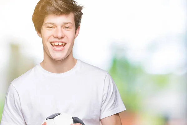 Joven Sosteniendo Pelota Fútbol Sobre Fondo Aislado Con Una Cara —  Fotos de Stock