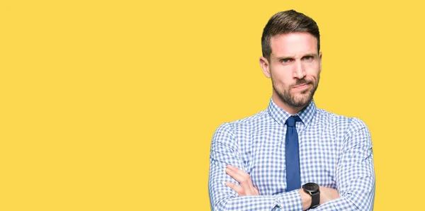 Handsome business man wearing tie skeptic and nervous, disapproving expression on face with crossed arms. Negative person.