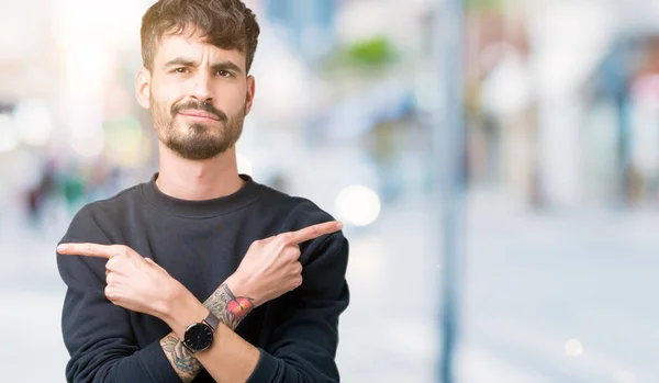 Joven Hombre Guapo Sobre Fondo Aislado Señalando Ambos Lados Con —  Fotos de Stock