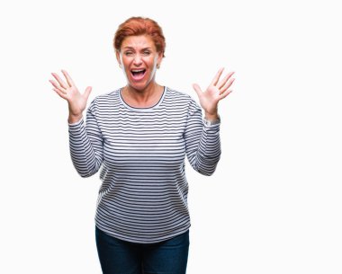 Atrractive üst düzey beyaz Kızıl saçlı kadın deli kutluyor arka plan izole ve başarı için kaldırdı kollarını açarak hayrete ve heyecanlı çığlık gözleri açık. Kazanan kavramı