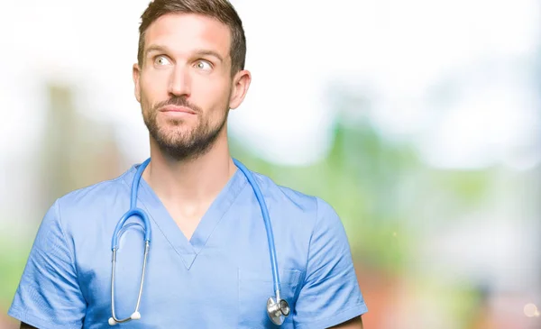 Bello Medico Uomo Indossa Uniforme Medica Sfondo Isolato Sorridente Guardando — Foto Stock