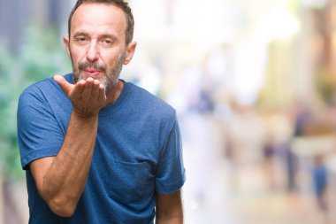 Orta yaş bir öpücük el ile güzel ve seksi olmak hava üfleme kamera bakarak izole arka plan üzerinde ağarmış komuta sizde. Aşk ifade.