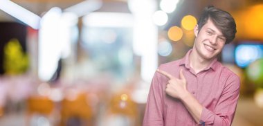 Genç yakışıklı iş adamı izole arka neşeli bir gülümseme ile el ve parmak kadar yan yüzünde mutlu ve doğal ifade ile işaret yüz üzerinden