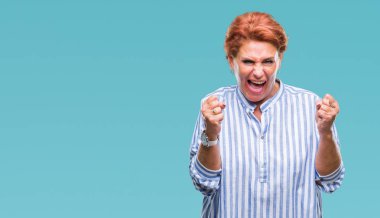 Atrractive üst düzey beyaz Kızıl saçlı kadın izole arka kolları olan başarı için heyecan üzerinde zafer kutluyor gülümseyen kaldırdı. Kazanan kavramı.