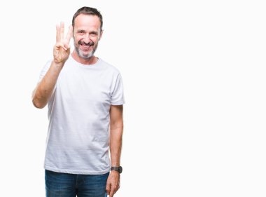 Orta yaş ağarmış komuta sizde gösterilen ve parmakları ile işaret izole arka plan üzerinde beyaz t-shirt giyen üç kendinden emin ve mutlu gülümseyerek iken numara.