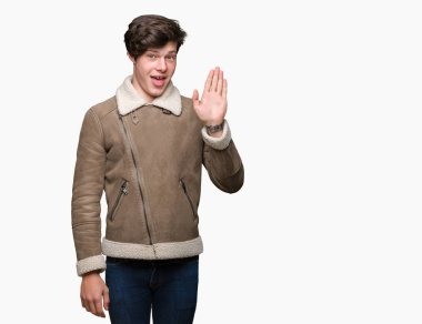 Yakışıklı delikanlı izole arka plan Waiving mutlu selam söyleyerek üzerinde kış ceket ve gülümseyen, dostça karşılama jest