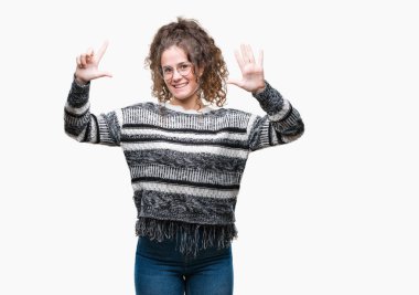 Güzel esmer kıvırcık saçlı Genç kız üzerinde gözlük takan gösterilen arka plan izole ve parmakları ile işaret kendinden emin ve mutlu gülümseyerek süre yedi numara.