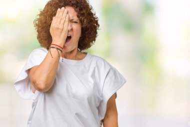 Yarım yüz, göz ve ağız el ile kapsayan Yawning yorgun arka plan üzerinde beyaz t-shirt giyen kadın güzel orta ager kıdemli izole. Acı yüzü acıyor.