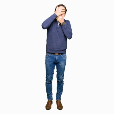 Orta yaş yakışıklı adamın bir kazak kapsayan gözleri giydiğini ve şaşırttı ve şok ellerle ağız. Duygu gizleme