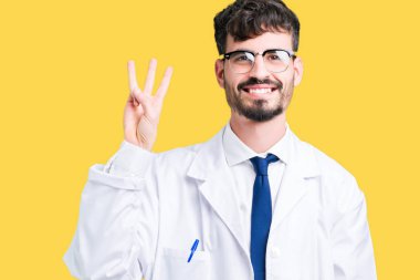 Gösterilen arka plan üzerinde beyaz önlük giyen genç profesyonel bilim adam izole ve parmakları ile işaret kendinden emin ve mutlu gülümseyerek iken üçüncü.
