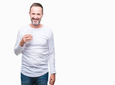 Orta yaş ağarmış komuta sizde ayakta ve diş gösterilen kendine güvenen bir gülümsemeyle gülümseyerek mutlu bir yüz ile izole arka plan üzerinde bardak su içme