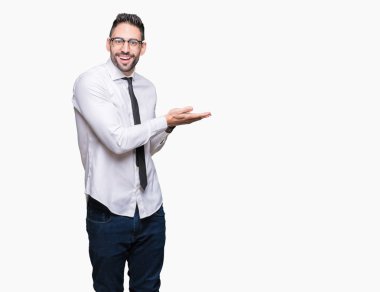 Üzerinde gözlük takan genç yakışıklı iş adamı izole arka plan el ve reklam mutlu ve kendinden emin gülümseyen sunulması avuç, yanında işaret