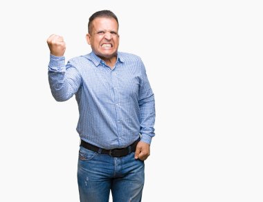 Orta yaş Arap iş adamı izole arka plan öfkeli ve sinirli sinirli ve öfke ile bağırarak süre öfkeli yumruk yükselterek üzerinde. Öfke ve agresif kavramı.