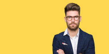 Yüz çapraz kolları üzerinde gözlük şüpheci ve sinir, onaylamayan ifade giyen genç yakışıklı iş adam. Negatif kişi.