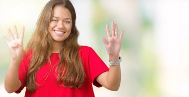 Gösterilen ve parmakları ile işaret izole arka plan üzerinde kırmızı t-shirt giyen genç güzel esmer kadın numara 9 kendinden emin ve mutlu gülümseyerek süre.