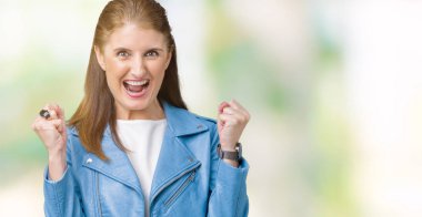 Güzel silah ile başarı için orta yaş Olgun kadın moda deri ceket izole arka plan kutlama üzerinde şaşırttı ve hayran kaldırdı ve gözleri açık. Kazanan kavramı.