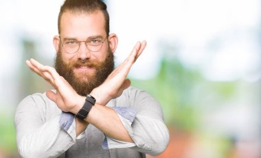 Genç Sarışın giyen gözlük ret ifade geçiş silah eksi işareti, kızgın surat yapıyor adam