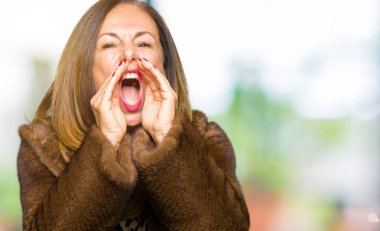 Vizon ceket ağzına sesle elleriyle kızgın bağırarak giyen güzel orta yaş zarif kadın