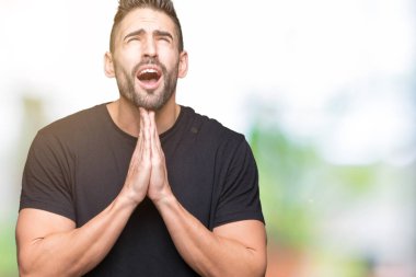 Yakışıklı delikanlı yalvarıyor ve umut ifade yüzünde çok duygusal ve endişe ile birlikte elleriyle dua izole arka plan üzerinde. Bağışlanmak. Din kavramı.