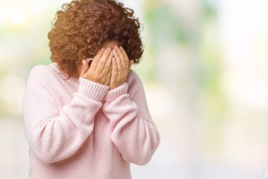 Ağlarken elleri ile yüz kapsayan üzücü ifade ile izole arka plan üzerinde pembe kazak ve güneş gözlüğü giyen güzel orta ager kıdemli kadın. Depresyon konsepti.