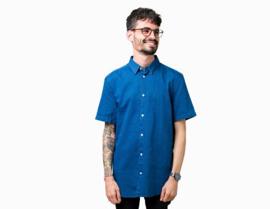 Uzak tarafına yüzünde, doğal ifade gülümseme ile seyir izole arka plan üzerinde gözlük takan yakışıklı delikanlı. Kendine güvenen gülüyor.