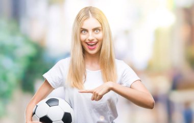 Futbol topu izole arka plan üzerinde çok mutlu el ve parmak ile işaret tutan genç güzel sarışın kadın