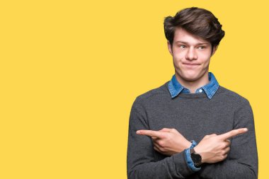 Genç yakışıklı zarif adam izole arka plan üzerinde işaretleme için her iki parmak, farklı yönde ile katılmıyorum