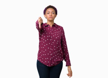 Mutsuz ve kızgın ret gösterilen ve başparmak aşağı hareketi ile negatif seyir izole arka plan üzerinde başörtüsü giyen güzel genç Afro-Amerikan kadın. Kötü ifade.