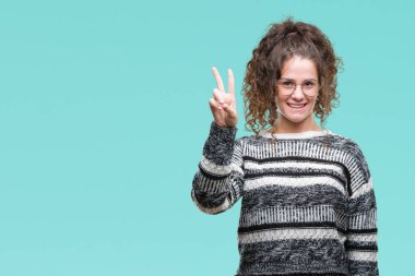 Güzel esmer kıvırcık saçlı Genç kız üzerinde gözlük takan gösterilen arka plan izole ve parmakları ile işaret kendinden emin ve mutlu gülümseyerek ise ikinci.