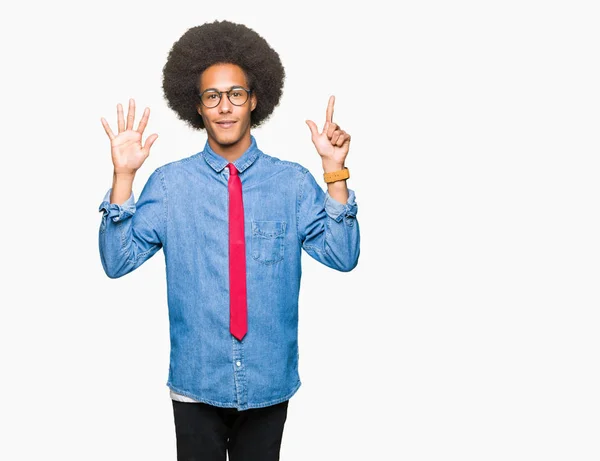 アフリカ系アメリカ人のビジネスマンで アフロの髪をしてメガネをかけ 赤いネクタイを見せて指で指さし 自信を持って笑顔で7番 — ストック写真