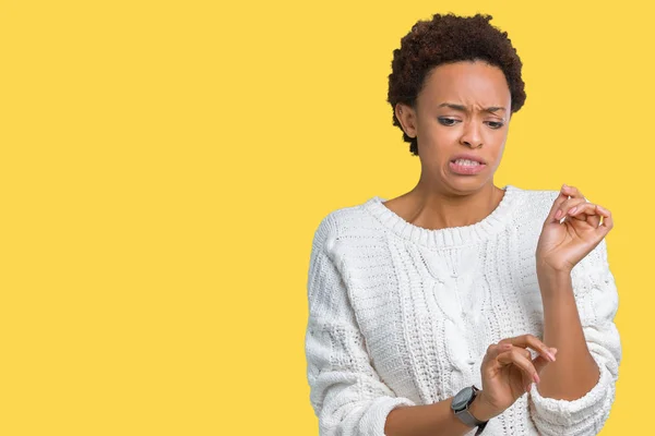 Beautiful young african american woman wearing sweater over isolated background disgusted expression, displeased and fearful doing disgust face because aversion reaction. With hands raised. Annoying concept.